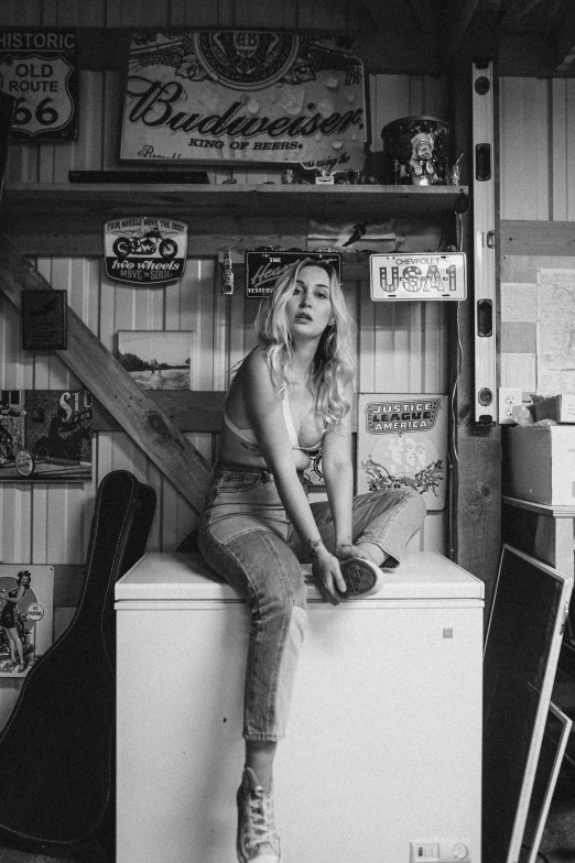 a black and white photo of a woman sitting on top of a refrigerator, a black and white photo, by Matt Cavotta, unsplash, photorealism, chloë grace moretz, oldwest, garage, various posed