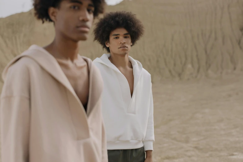 two men standing next to each other in the desert, by Daniel Seghers, trending on pexels, renaissance, beige hoodie, fashion model features, with textured hair and skin, in white clothes