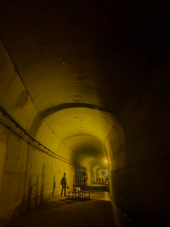 a couple of people that are standing in a tunnel, 8k 28mm cinematic photo, underground bunker, nighttime!, electricity archs