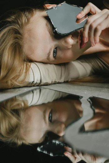 a woman taking a picture of herself with her cell phone, inspired by Elsa Bleda, trending on pexels, photorealism, lying on an abstract, wearing mirrored sunglasses, portrait of kim petras, todd hido