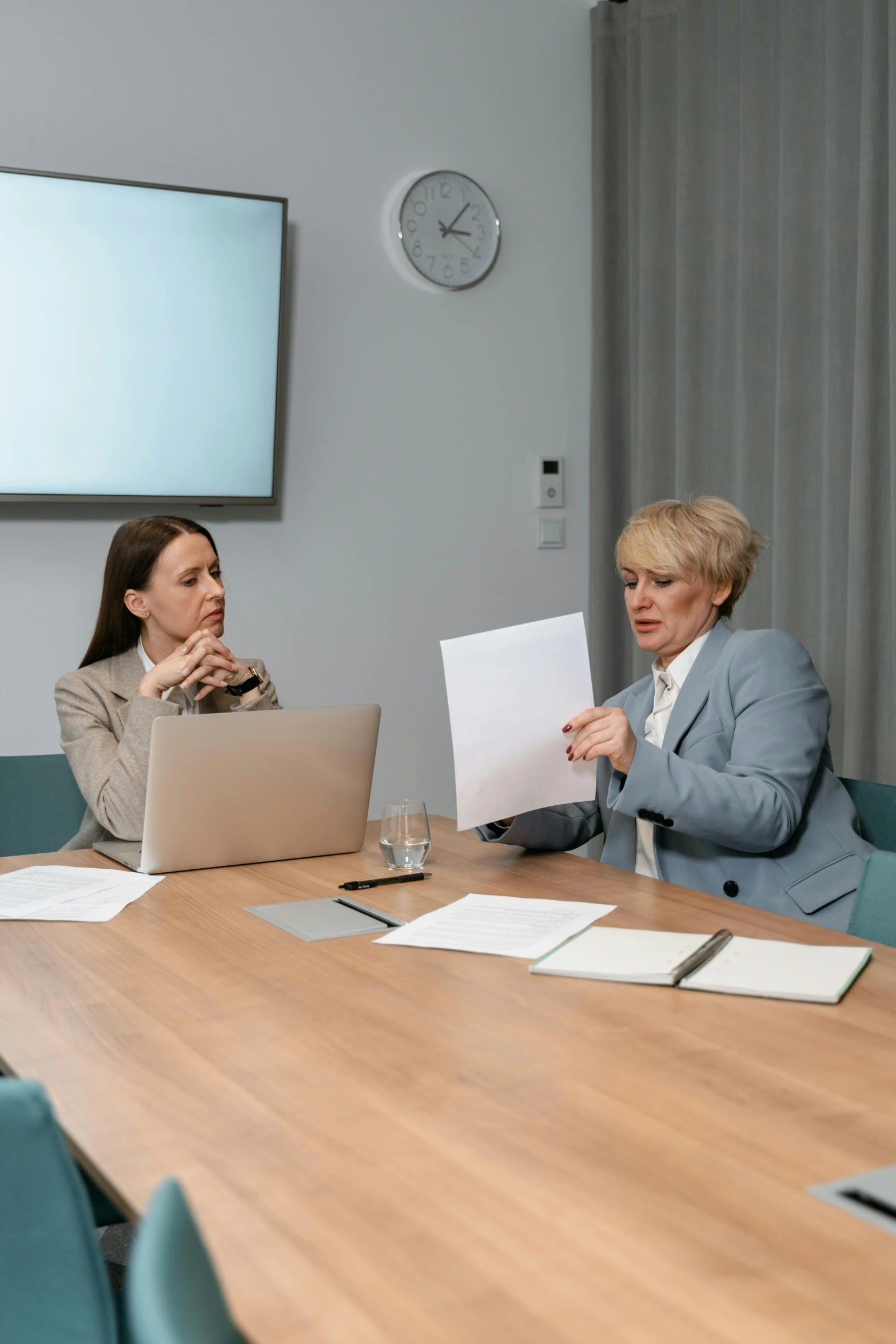 a group of people sitting around a table with laptops, by Andries Stock, arbeitsrat für kunst, female lawyer, background image, two women, high quality picture