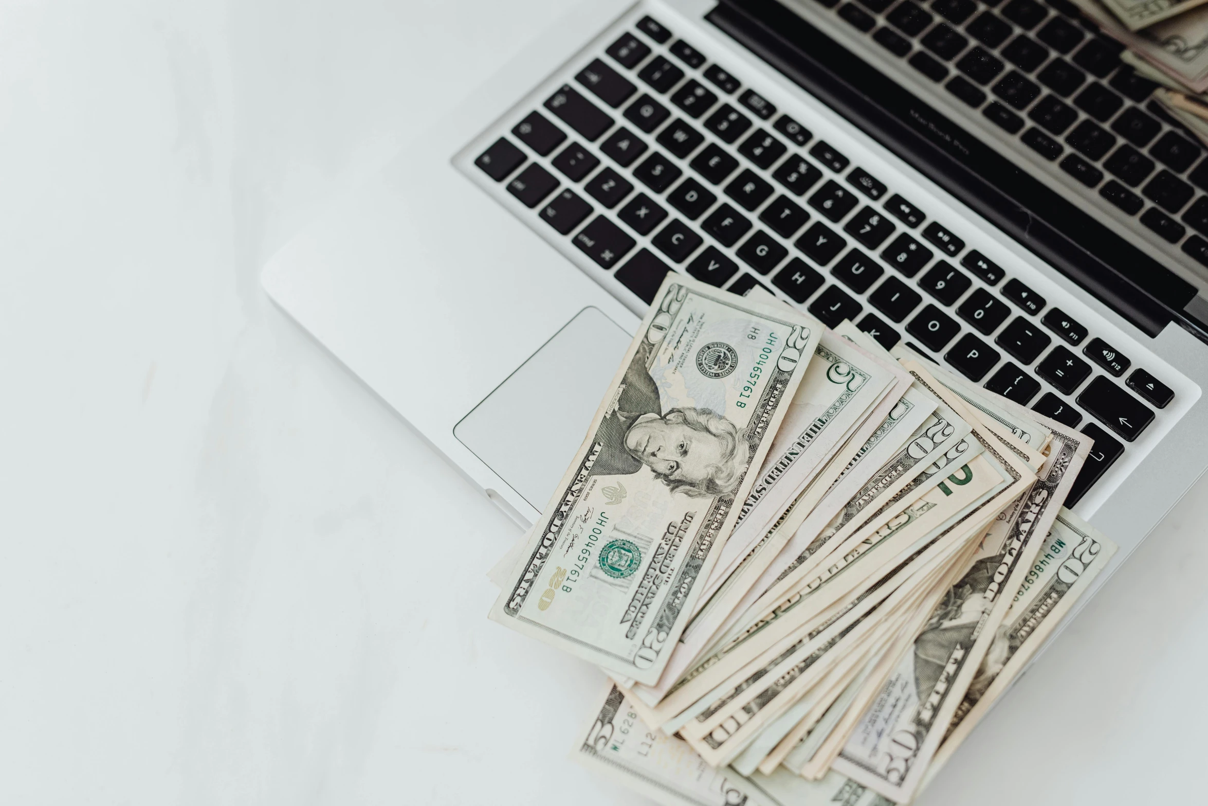 a laptop computer sitting on top of a pile of money, by Emma Andijewska, trending on unsplash, flatlay, low quality photo, 5k, tiny details