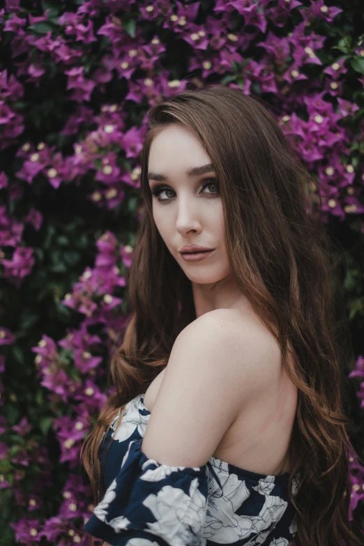 a woman standing in front of purple flowers, an album cover, pexels contest winner, lilly collins, 5 0 0 px models, portrait sophie mudd, lovingly looking at camera