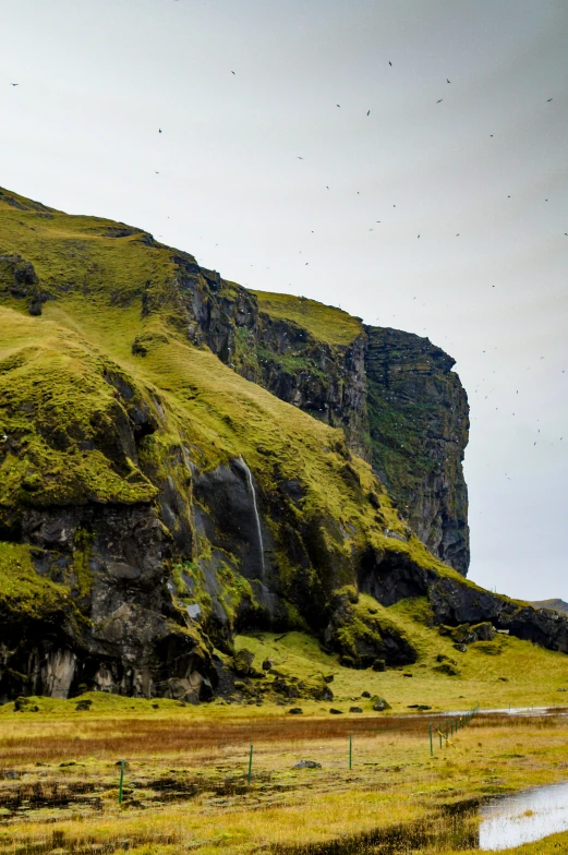 a herd of sheep standing on top of a lush green hillside, poster art, by Muggur, unsplash, lava waterfalls, flying rocky island, high-resolution photo, multiple stories