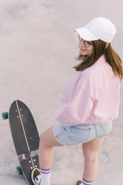 a young woman sitting on top of a skateboard, trending on unsplash, light pink, cropped shirt with jacket, croptop and shorts, product introduction photo