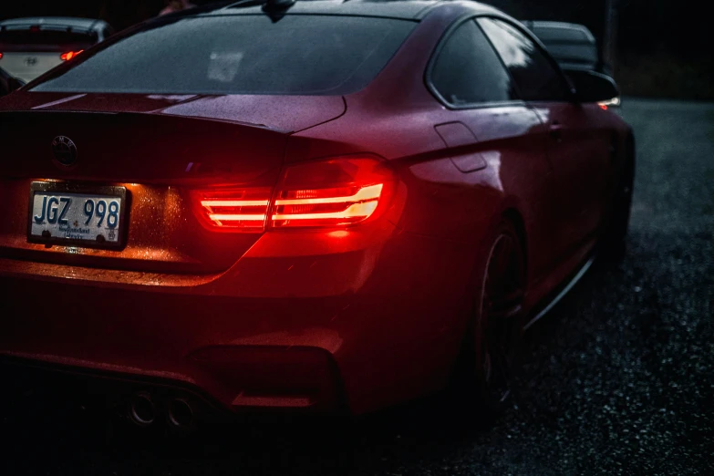 a red car parked on the side of the road, by Adam Marczyński, pexels contest winner, rear lighting, bmw, thin glowing lights, hyper realistic lighting