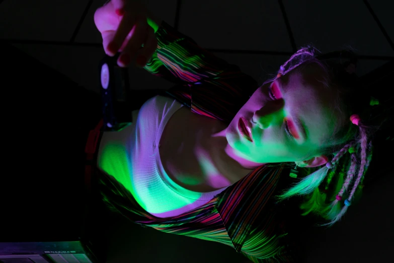 a woman holding a knife in front of a laptop, a hologram, pexels contest winner, holography, lying down, black light rave, portrait top light, top down shot