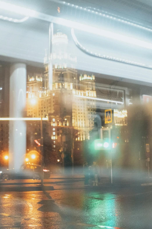 a blurry picture of a city street at night, by Alexander Mann, city of the future in russia, promo image, glass reflections, billboard image