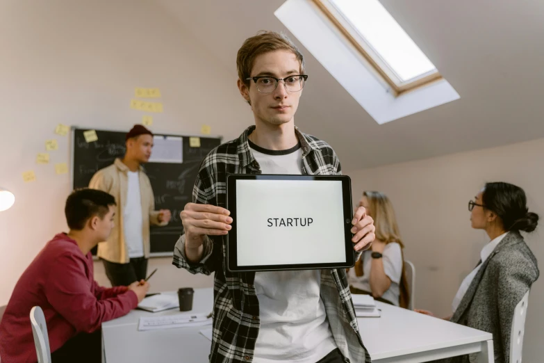 a man holding a tablet in front of a group of people, a picture, trending on pexels, starship, studious, promotional picture, stern look