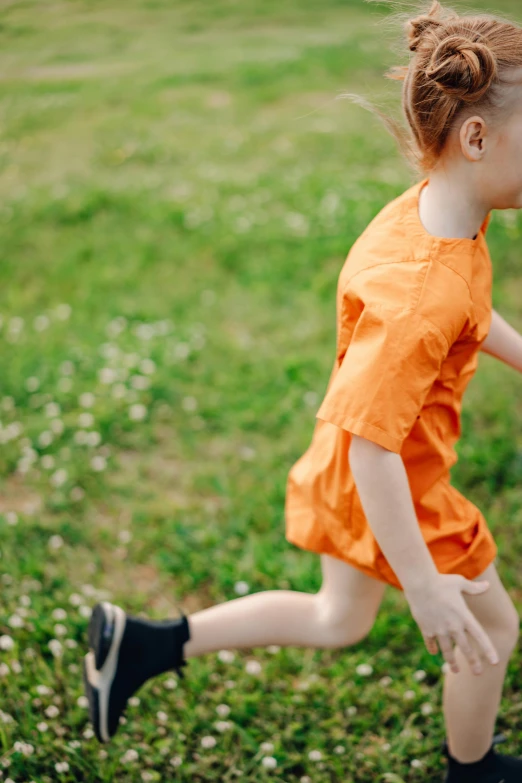a little girl running with a frisbee in her hand, an album cover, inspired by Kate Greenaway, pexels, wearing orange prison jumpsuit, young boy, sport clothing, lush surroundings