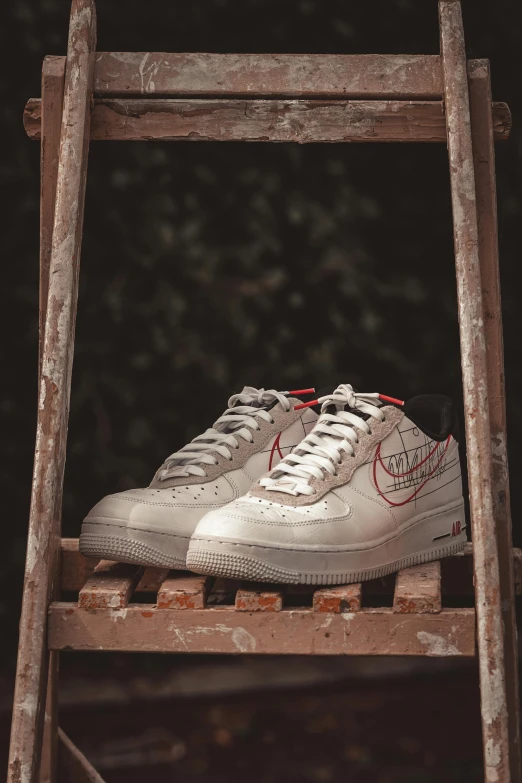 a pair of sneakers sitting on top of a ladder, air force, silver white gold red details, promo image, ground level shot