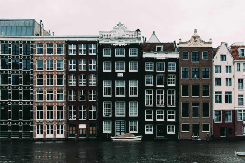 a row of buildings next to a body of water, by Jonas De Ro, pexels contest winner, neoclassicism, dutch style, high rise buildings, cozy, : :