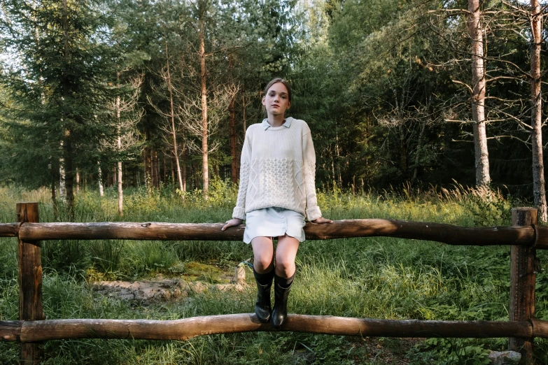 a woman sitting on top of a wooden fence, a portrait, unsplash, realism, andrey tarkovsky, portrait image, dafne keen, standing astride a gate