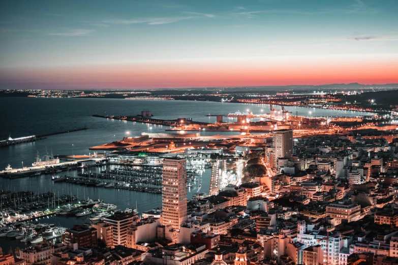 an aerial view of a city at night, pexels contest winner, a photo of the ocean, spanish, hypersaturated, twilight skyline