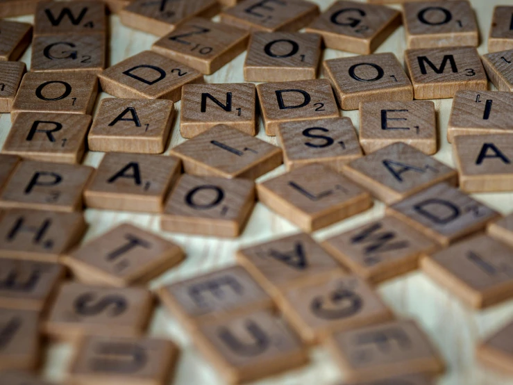a pile of scrabbles sitting on top of a table, by Emma Andijewska, unsplash, fan favorite, brown, mosaic, finding words