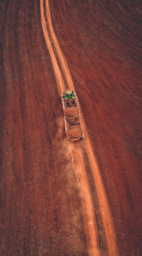 a tractor driving down a dirt road in the middle of a field, australian tonalism, top view of convertible, low quality photo, instagram photo, on the orange surface of mars