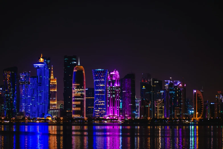 a view of a city at night from across the water, pexels contest winner, hurufiyya, magenta and crimson and cyan, arabia, slide show, skyscapers