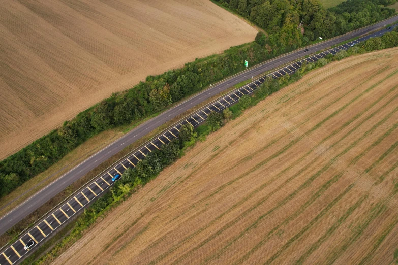 a large long train on a steel track, by Matthias Stom, pexels contest winner, land art, roads among fields, top down perspecrive, 15081959 21121991 01012000 4k, panoramic anamorphic