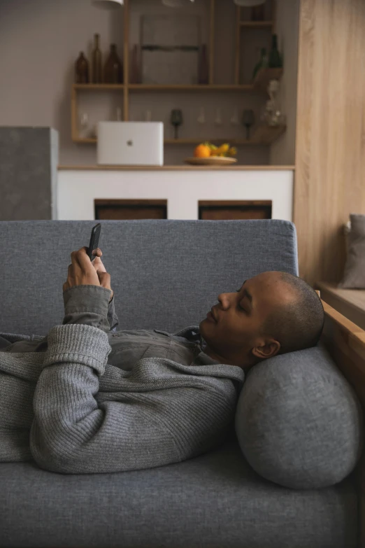 a man laying on a couch using a cell phone, trending on pexels, grey, photo of a black woman, watching tv, ignant