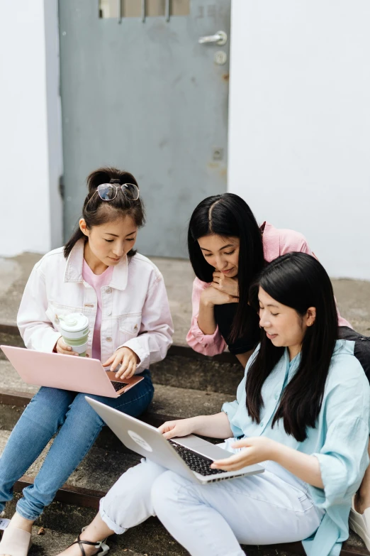 three women sitting on steps looking at a laptop, trending on pexels, young asian girl, teaching, promotional image, university