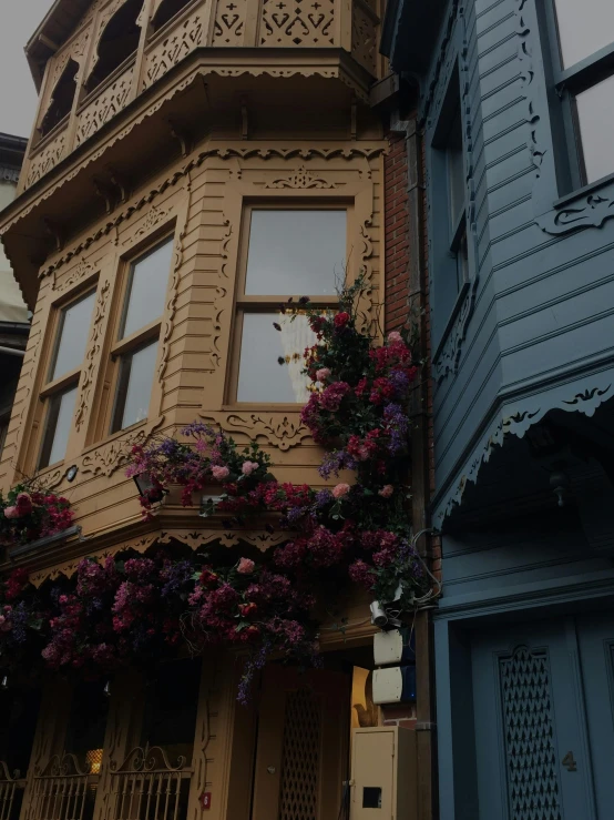 a couple of buildings that are next to each other, trending on unsplash, art nouveau, wooden house, flowers and gold, low quality photo