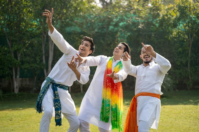 a group of men standing on top of a lush green field, an album cover, shutterstock, wearing a kurta, colors white!!, dancing with each other, wearing festive clothing