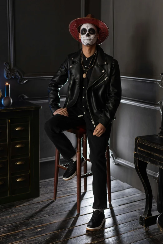 a man sitting on a chair in a room, a portrait, inspired by Yasutomo Oka, trending on pexels, vanitas, dressed in biker leather, tim booth, official store photo, fukaya yuichiro