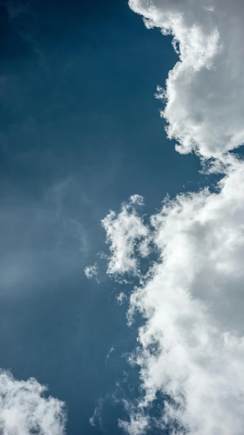 a jetliner flying through a cloudy blue sky, unsplash, minimalism, low angle 8k hd nature photo, cumulus, ignant, shot on sony a 7