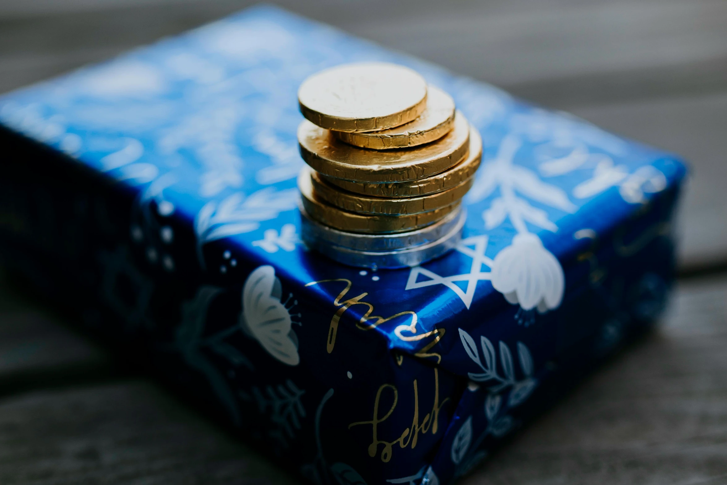 a stack of coins sitting on top of a blue box, by Julia Pishtar, pexels contest winner, festive, gold foil, blue velvet, elliot alderson