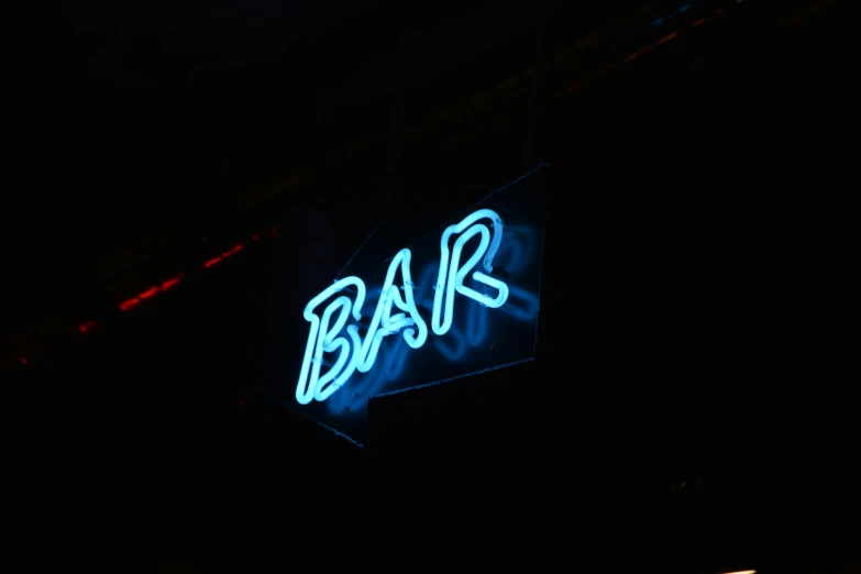 a neon sign on the side of a building, pexels, sitting at the bar, black and blue, baars, closeup photograph