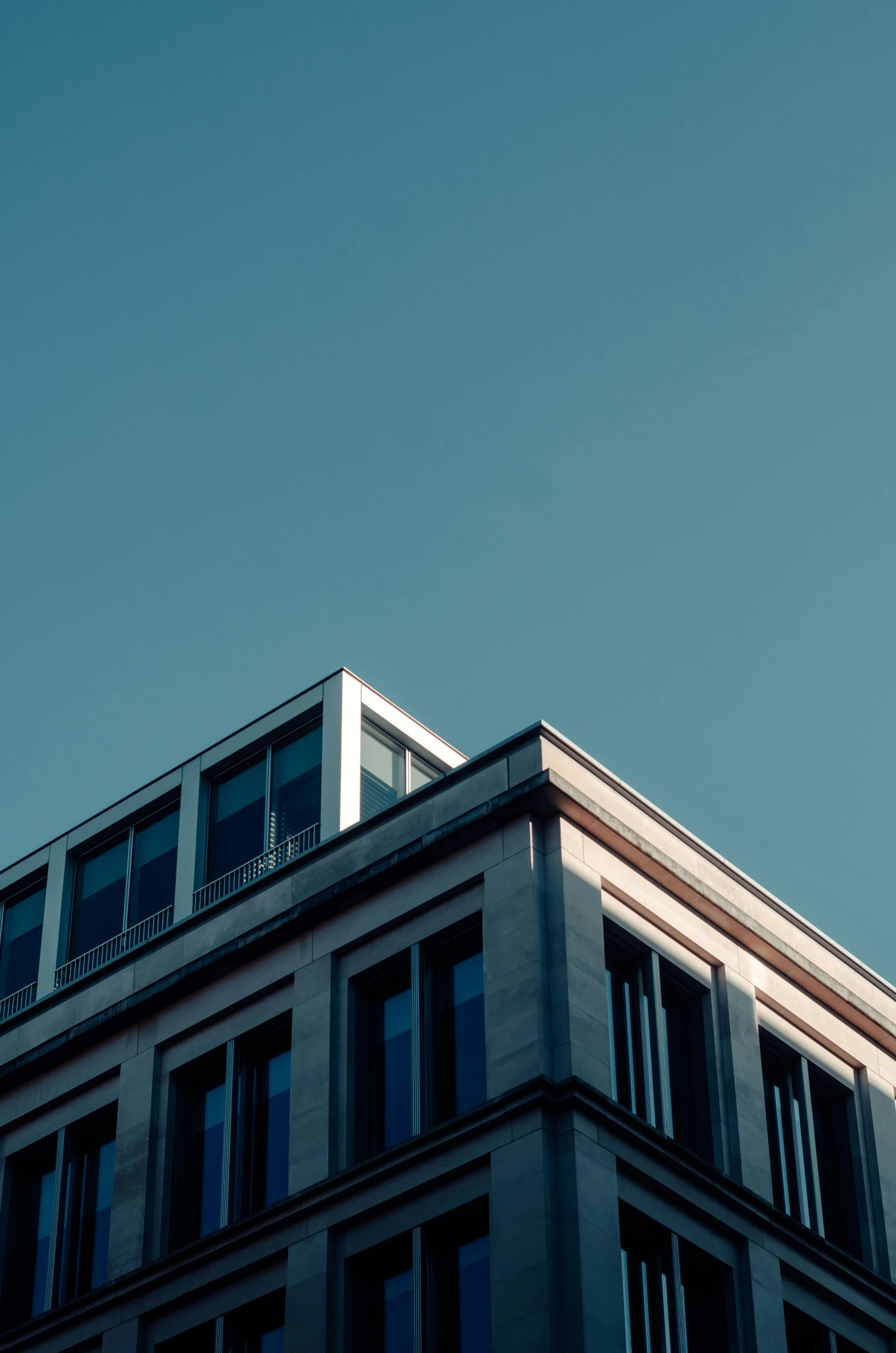 a tall building with a clock on top of it, unsplash, light blue clear sky, sharp roofs, low quality photo, flat minimalistic