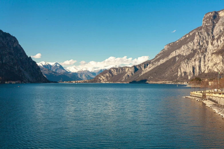 a body of water with mountains in the background, by Carlo Martini, pexels contest winner, visual art, sunny day, boka, multiple stories, f/1.4