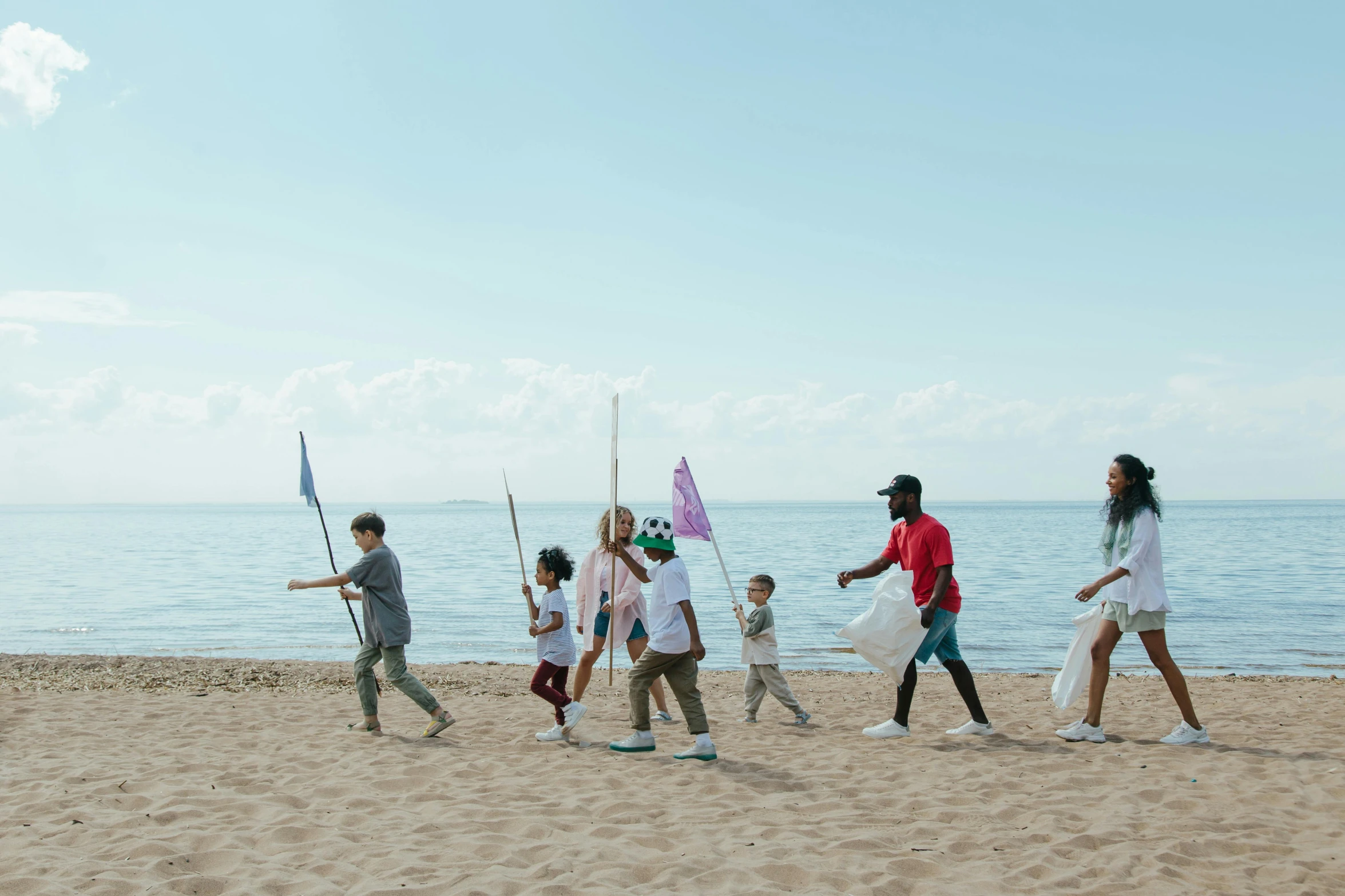 a group of people walking on top of a sandy beach, by Arabella Rankin, pexels contest winner, holding a white flag, scattered rubbish, children's, promotional image