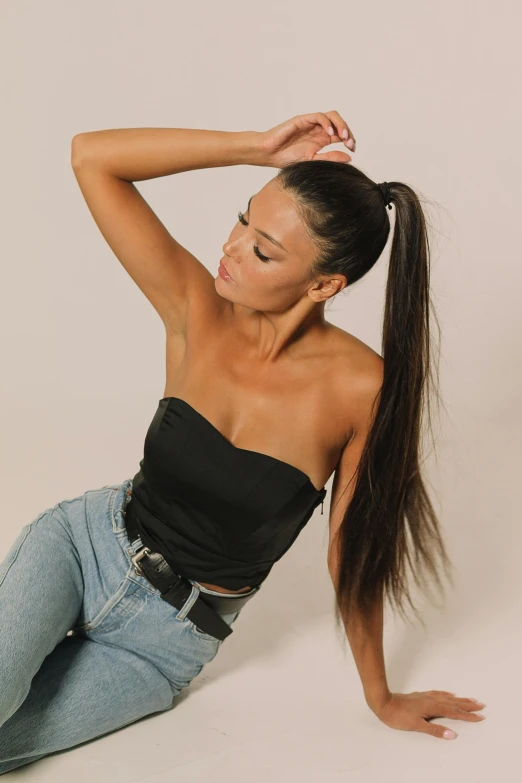 a woman sitting on the ground with her hair in a ponytail, trending on pexels, renaissance, wearing a cropped black tank top, model standing pose, floating long hair, tanned