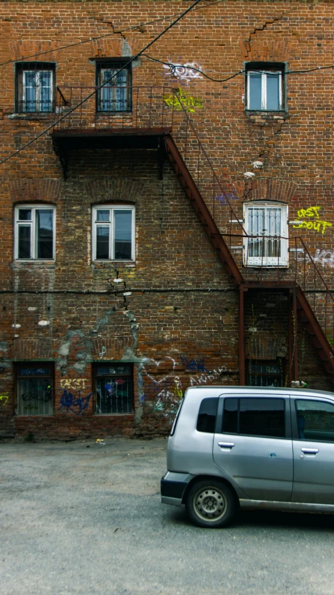 a van parked in front of a brick building, pexels contest winner, graffiti, rutkowski ilya krenz nixeu wlop, old color photo, small buildings, front and side elevation