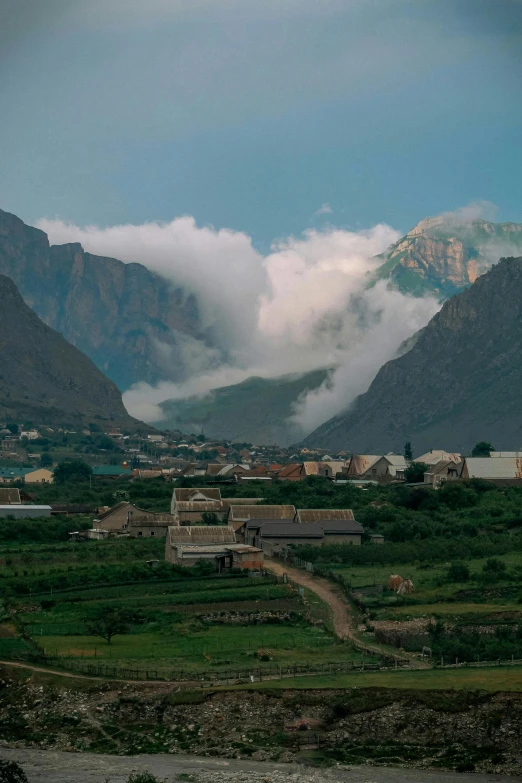 a view of a valley with mountains in the background, by Muggur, small town surrounding, cotton clouds, early 2 0 0 0 s, lut