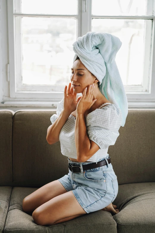 a woman sitting on a couch with a towel on her head, inspired by Elsa Bleda, trending on pexels, renaissance, flattering hair, petite body, sweating, pastel clothing