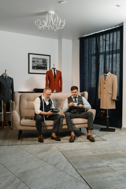 two men sitting on a couch in a room, by Alexander Fedosav, pexels contest winner, tailored clothing, product display, storefront, dmitry prozorov style