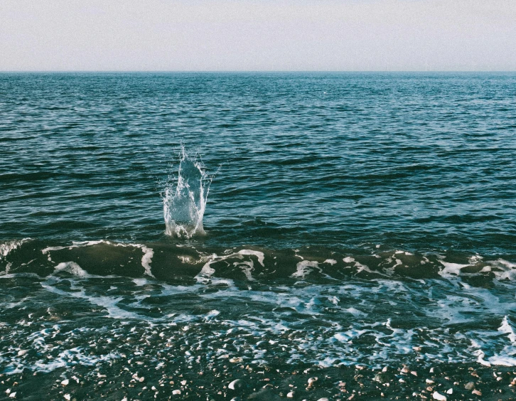 a splash of water in the middle of a body of water, an album cover, pexels contest winner, minimalism, black sea, beaches, lo fi, crashing waves