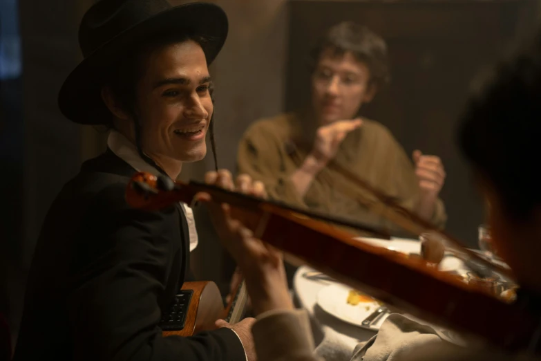 a man in a top hat playing a violin, pexels contest winner, avan jogia angel, scene from a dinner party, robert sheehan, [ theatrical ]