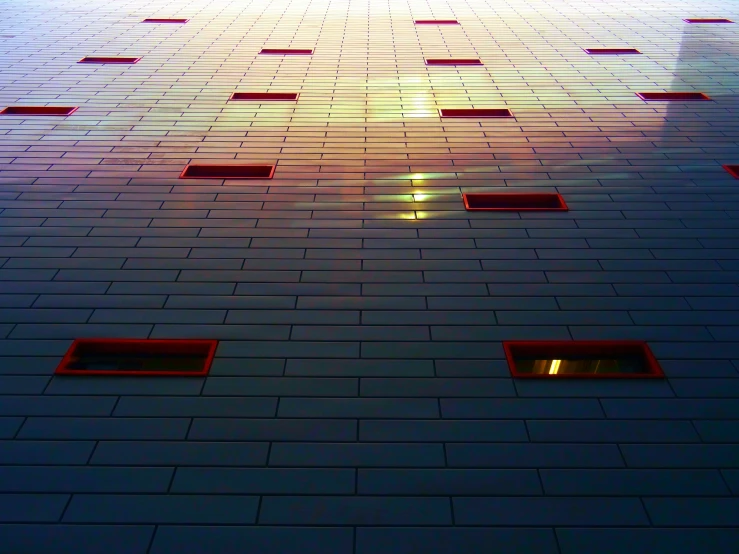 a very tall building with a lot of windows, a mosaic, by Jan Rustem, unsplash, light and space, light red and deep blue mood, square lines, gradients and soft light, metal cladding wall