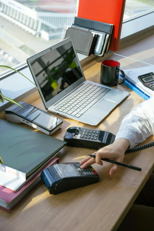 a woman sitting at a desk using a cell phone, laptops, hands on counter, thumbnail, multiple stories