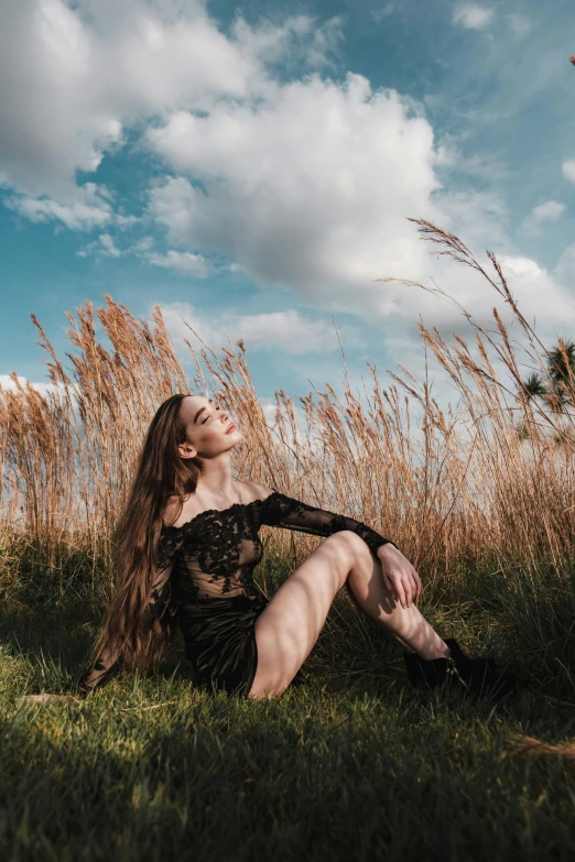 a woman sitting on top of a lush green field, an album cover, inspired by Elsa Bleda, pexels contest winner, renaissance, wearing a black bodysuit, instagram model, bright sky, profile pic