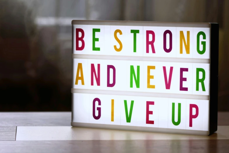 a sign that says be strong and never give up, pexels, light box, brightly coloured, bust, workout