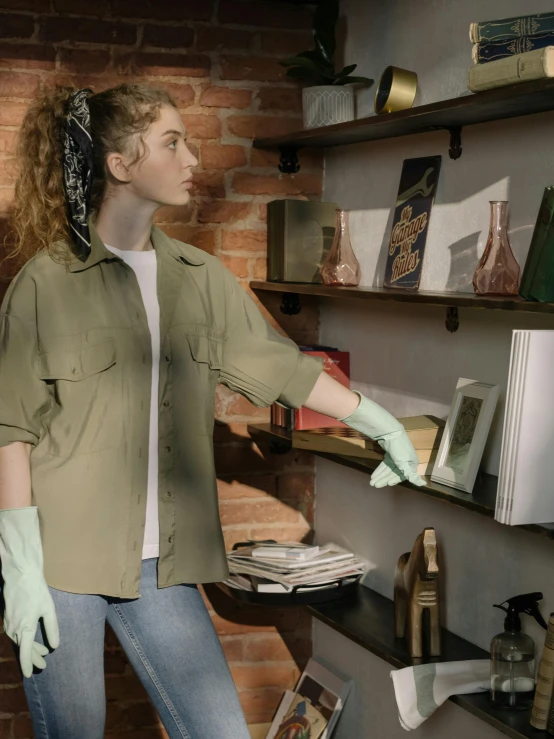 a woman in a green shirt is cleaning a bookshelf, a colorized photo, inspired by Elsa Bleda, hyperrealism, holding arms on holsters, worksafe. cinematic, off - white collection, wax figure