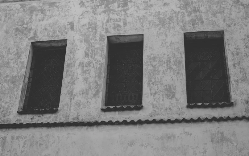 a black and white photo of three windows on a building, a black and white photo, by Ivana Kobilca, pexels, postminimalism, dirty walls, background image, realistic old photo, high details photo