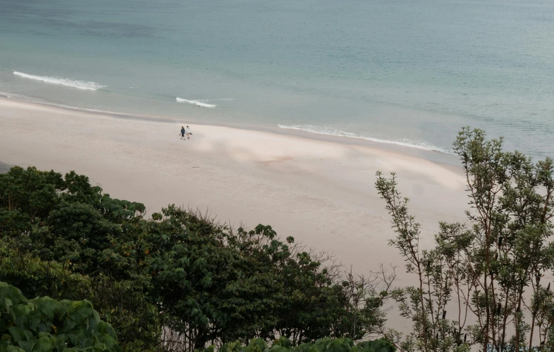 a couple of people standing on top of a sandy beach, down there, tranquillity, 1km tall, beach setting