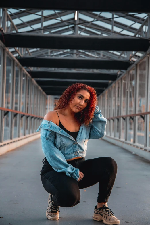 a woman with red hair squatting on a bridge, trending on pexels, doja cat, confident poses, slightly pixelated, handsome girl