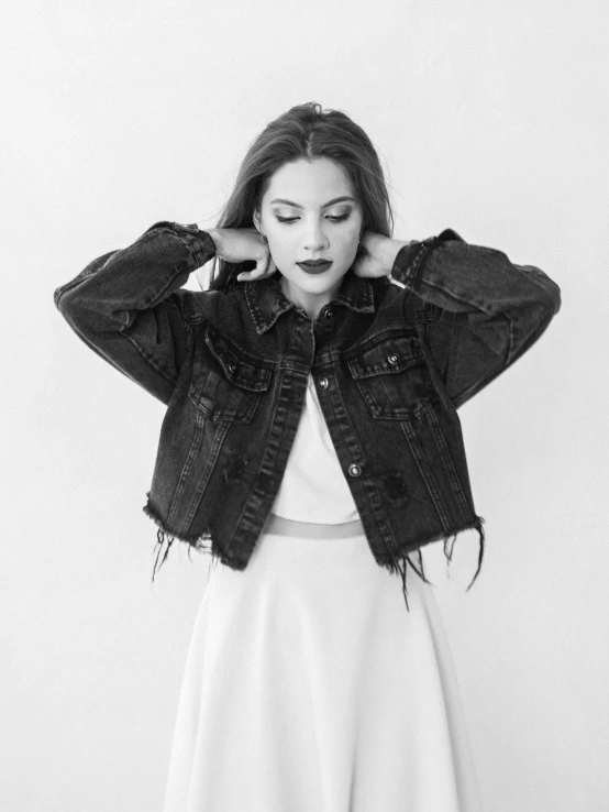 a black and white photo of a woman in a white dress, a black and white photo, by Lucia Peka, pexels, denim jacket, miranda cosgrove, promotional image, vintage clothing