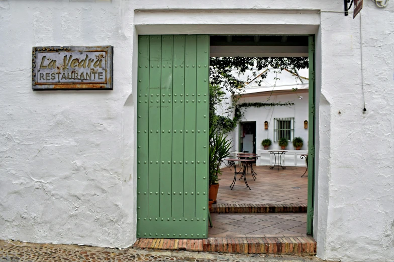 a green door is open on a white building, inspired by Eugenio de Arriba, verdadism, restaurant in background, 3 mary's, cottages, map